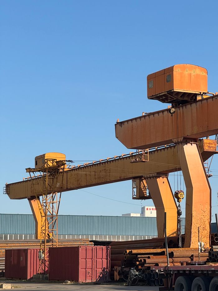Large industrial cranes in a sunny outdoor setting, conveying industry and construction themes.